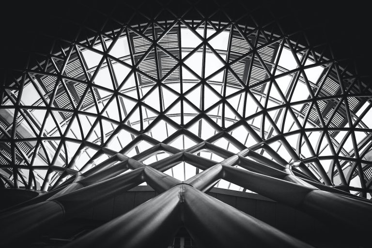 Low Angle Photography of Metal Building on Grayscale